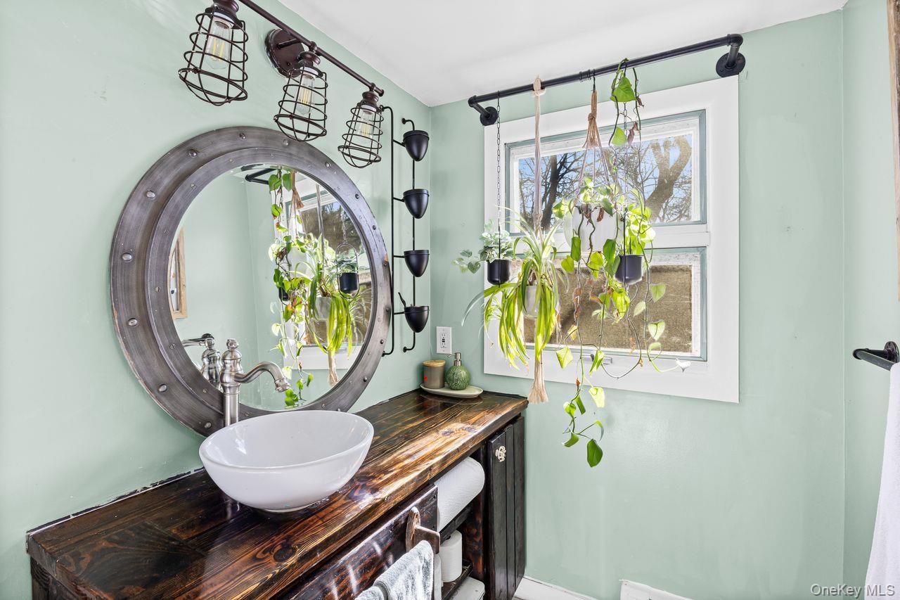 50 Poseidon Road Rocky Point, NY 11778 - Photo 19 of 47 a bathroom with a toilet sink and mirror