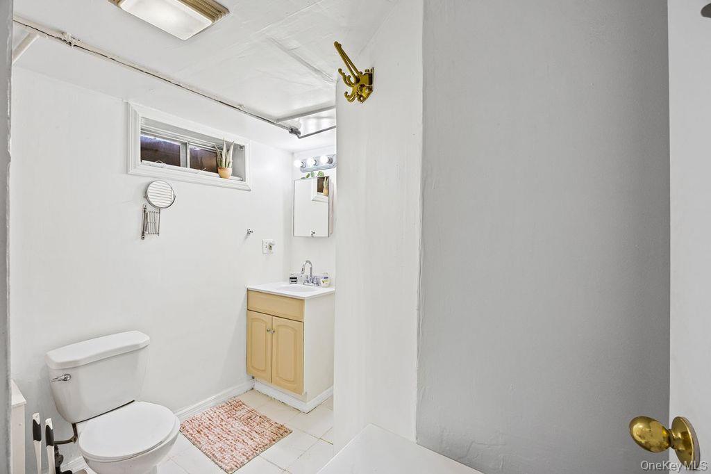 50 Poseidon Road Rocky Point, NY 11778 - Photo 28 of 47 a white toilet sitting next to a bathroom sink and vanity