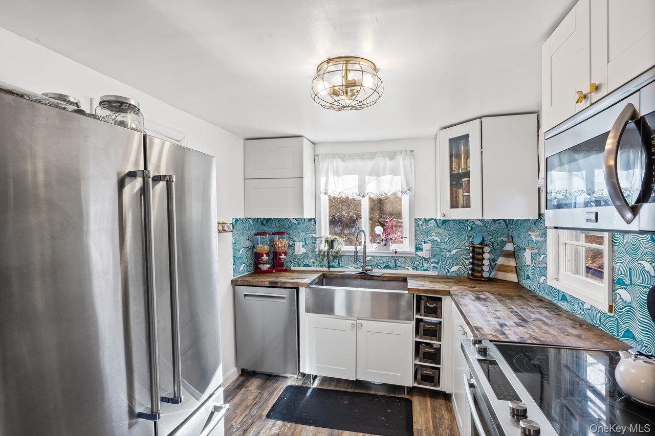 50 Poseidon Road Rocky Point, NY 11778 - Photo 9 of 47 a kitchen with a refrigerator a sink and cabinets
