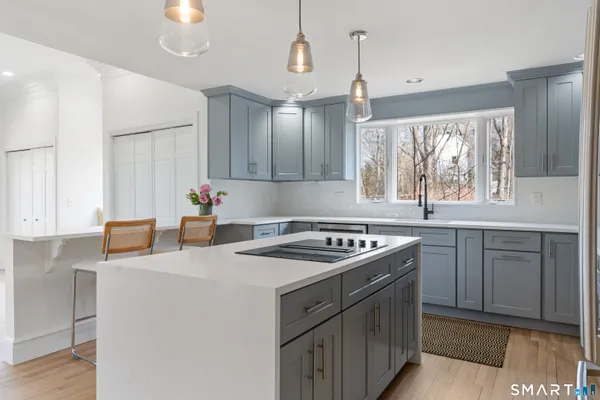 a kitchen that has a sink a stove and cabinets