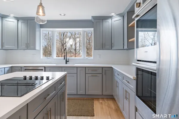 a kitchen with a sink stove top oven and cabinets