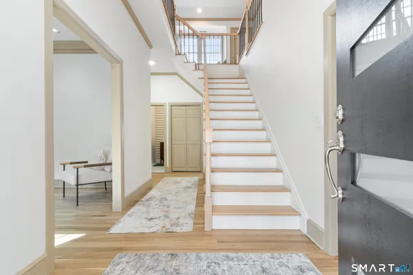 a view of entryway and hall with wooden floor