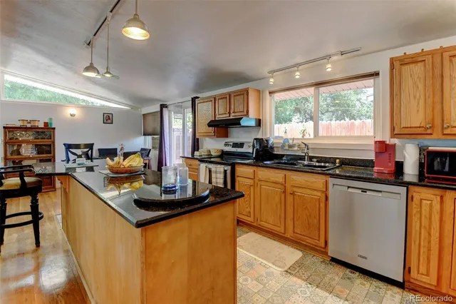 a kitchen with stainless steel appliances granite countertop a sink stove and refrigerator