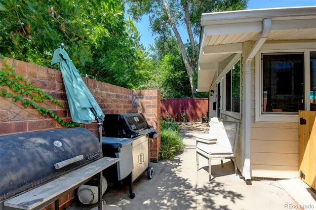 a view of a patio with table and chairs potted plants with wooden floor and fence