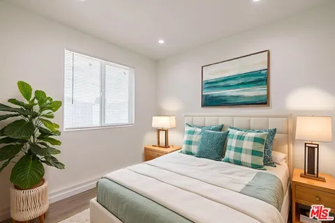 a bedroom with a bed and a painting on the wall