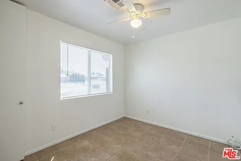 an empty room with a window and a fan