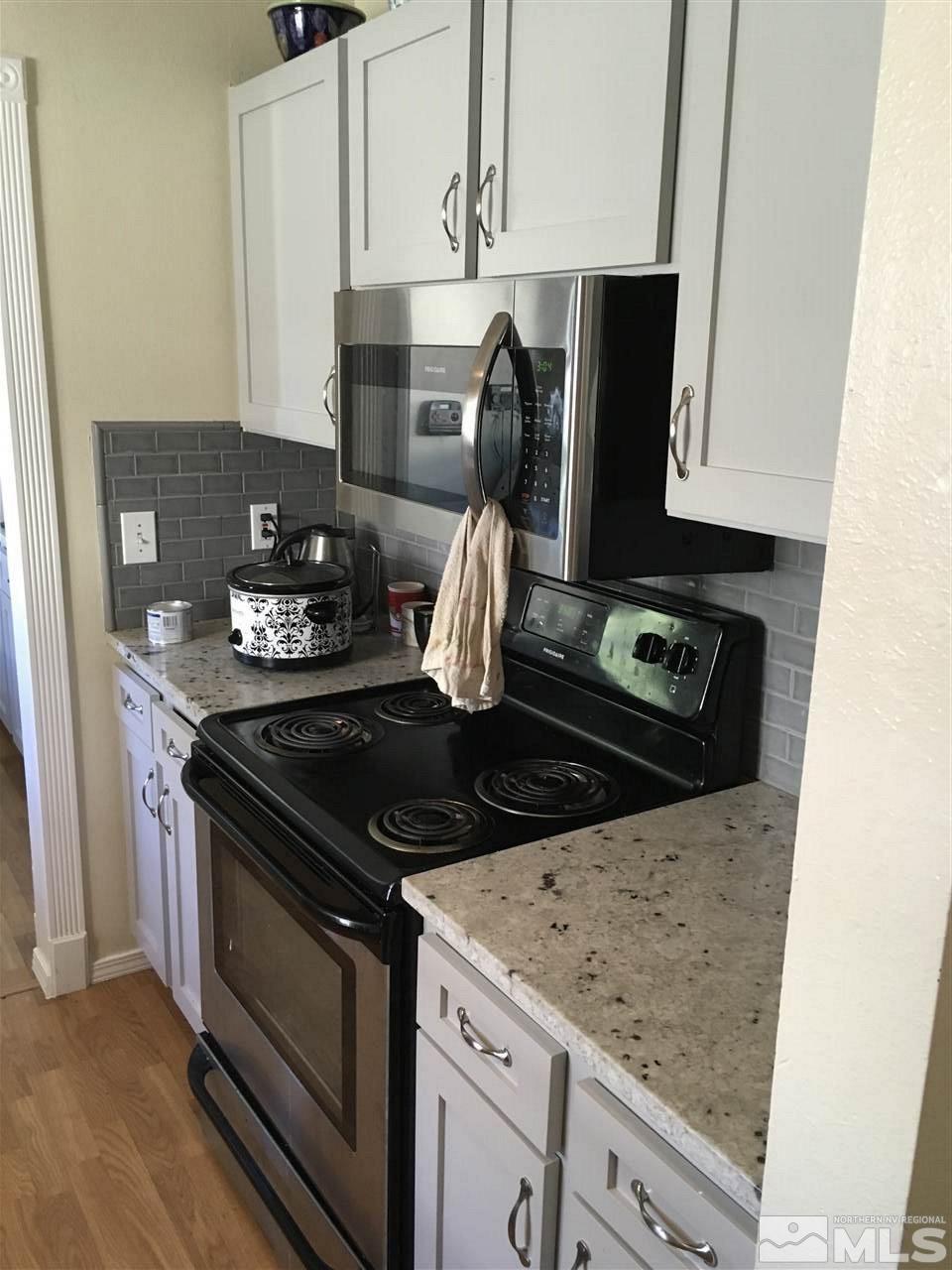 3655 Everett Drive Reno, NV 89503 - Photo 5 of 21 a kitchen with granite countertop a stove and a white cabinets