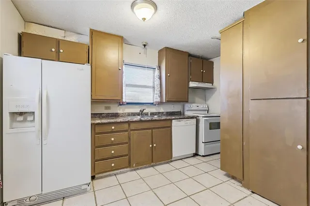 a kitchen with a refrigerator sink and cabinets
