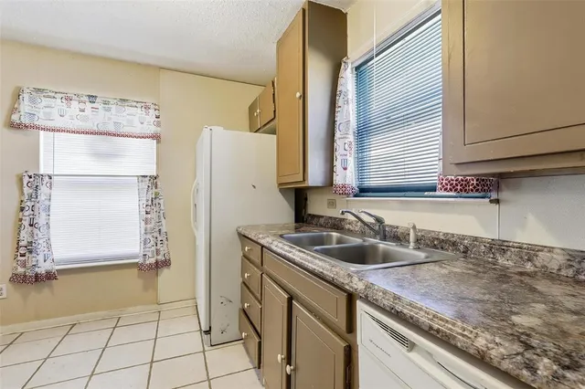 a kitchen with a sink a refrigerator and cabinets