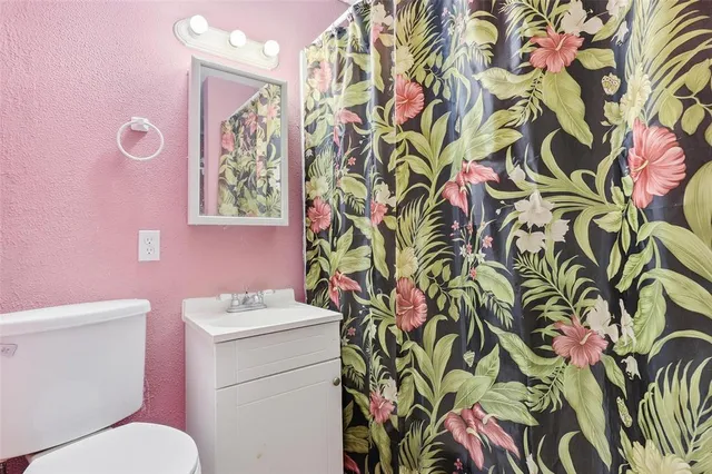 a bathroom with a sink and mirror with toilet