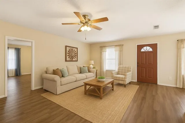 a living room with furniture and a ceiling fan