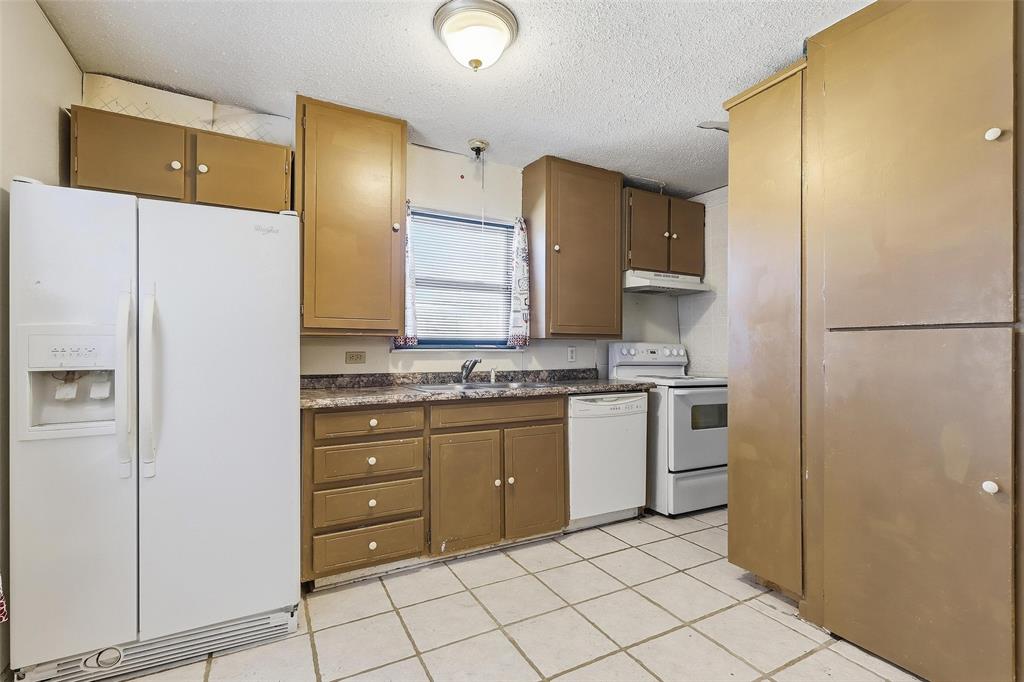 3822 Ragged Rock Court Joshua, TX 76058 - Photo 5 of 34 a kitchen with a refrigerator sink and cabinets