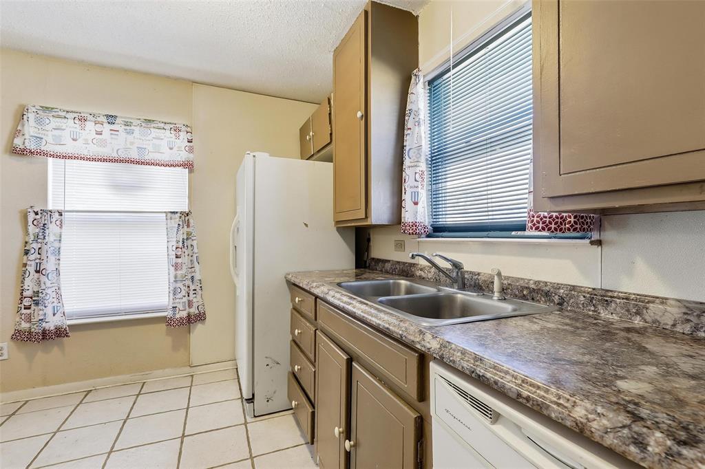 3822 Ragged Rock Court Joshua, TX 76058 - Photo 7 of 34 a kitchen with a sink a refrigerator and cabinets