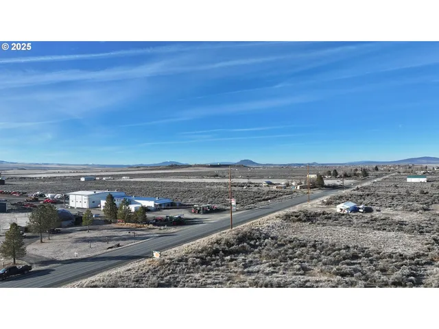 a view of a dry yard with wooden fence