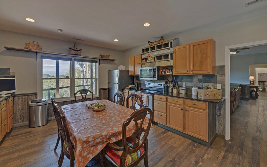 280 Cherokee Court Ellijay, GA 30540 - Photo 35 of 73 a kitchen with stainless steel appliances granite countertop a stove a sink a microwave a dining table and chairs
