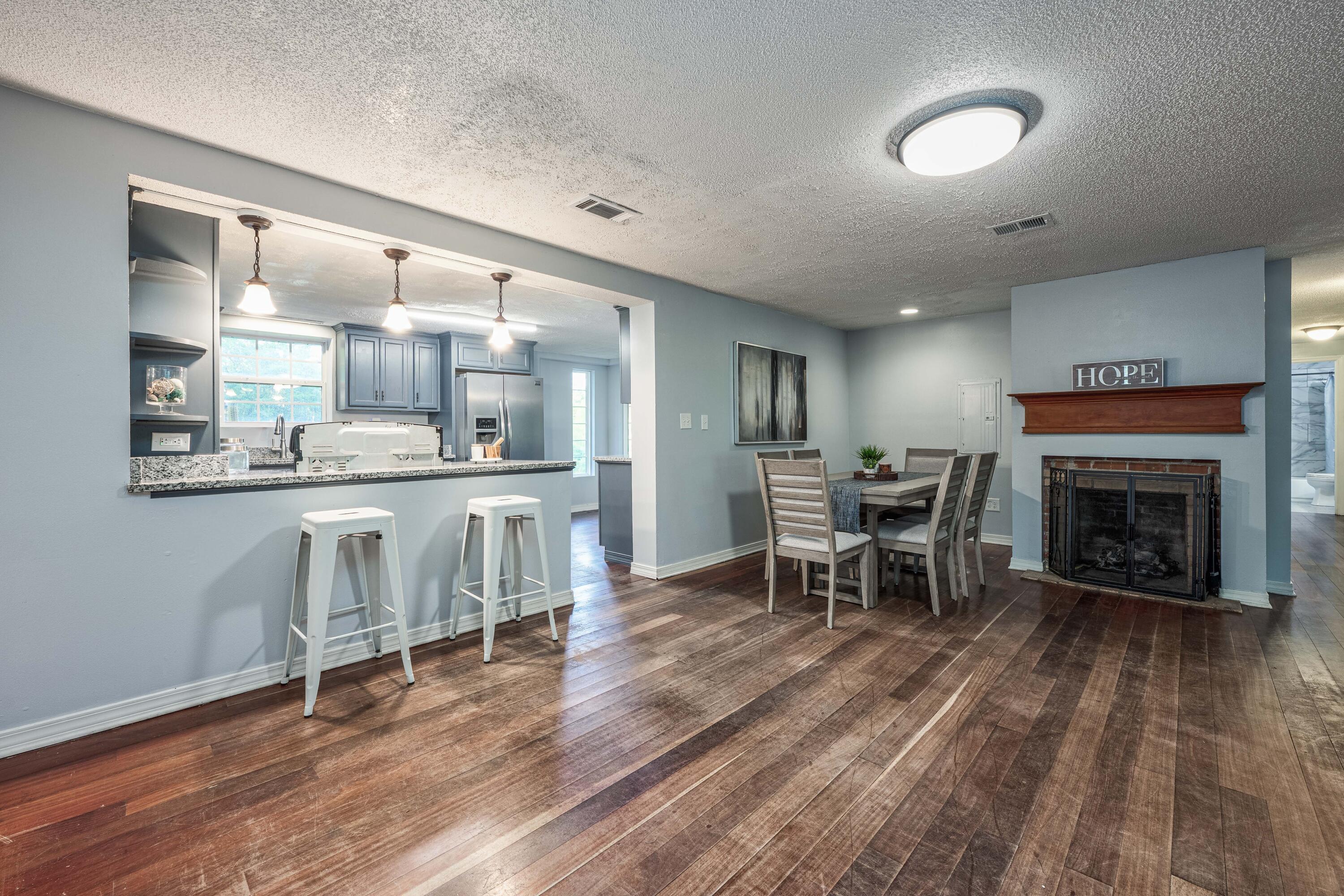 1838 Wadsworth Road Baker, FL 32531 - Photo 19 of 71 a living room with furniture a fireplace and kitchen view