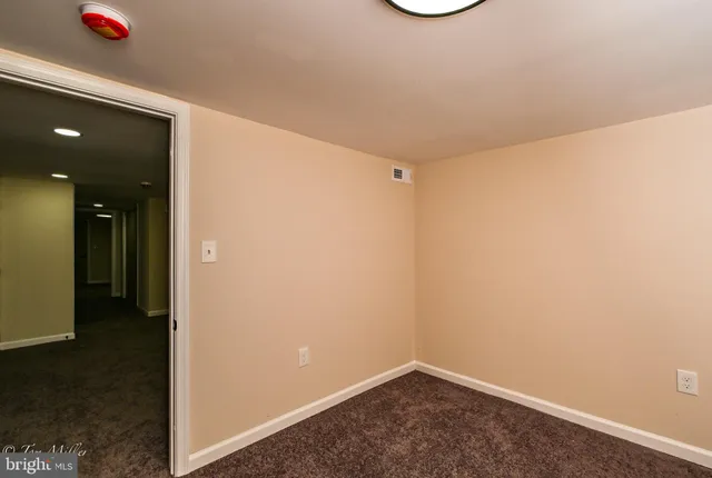 an empty room with a ceiling fan and wooden floor