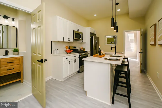 a kitchen that has a lot of cabinets a sink and appliances in it