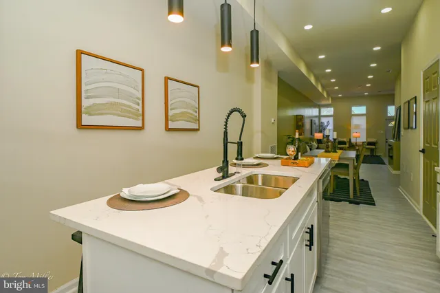 a kitchen with a sink dishwasher and a stove with wooden floor