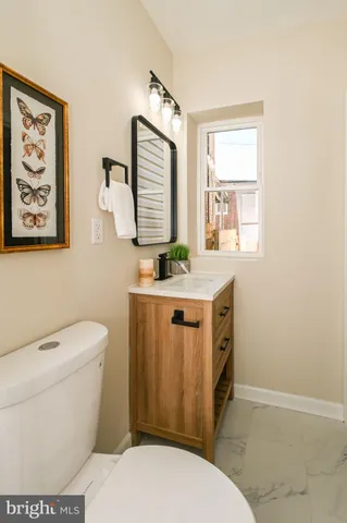 a bathroom with a toilet a sink a vanity and mirror