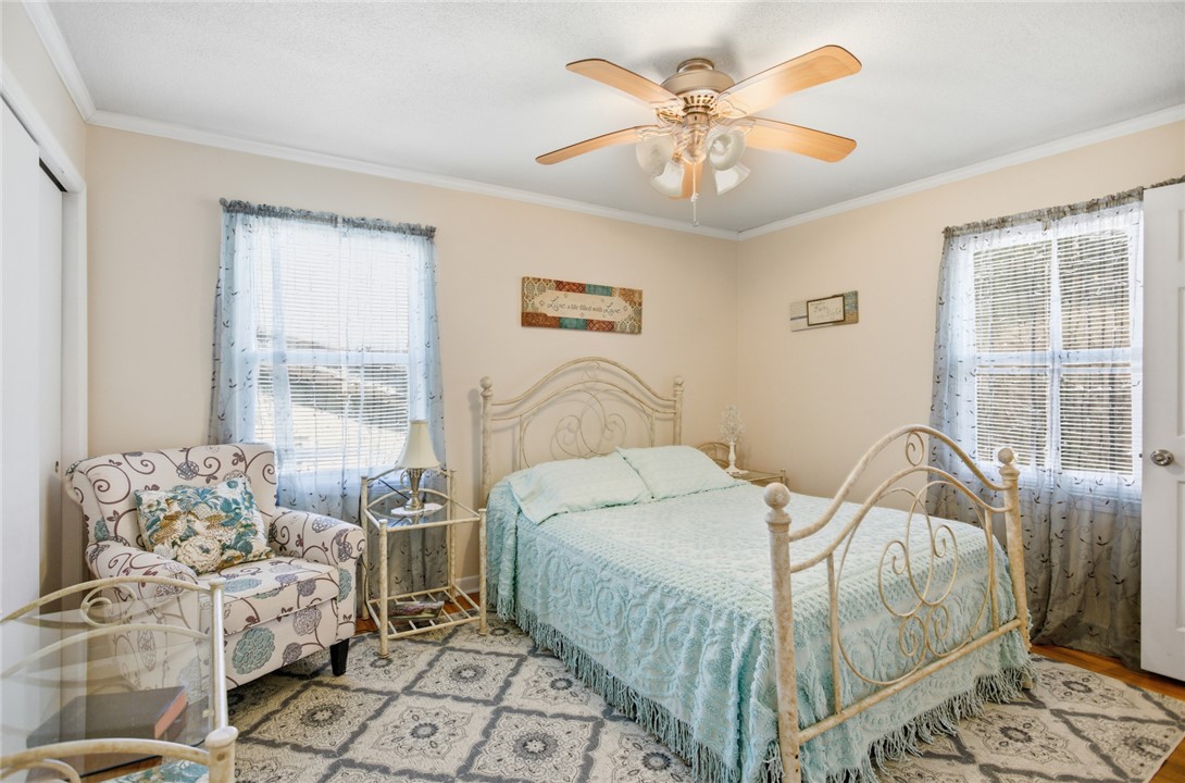 108 Hodge Street Abbeville, SC 29620 - Photo 15 of 39 A comforting bedroom space featuring durable hardwood flooring and a stylish ceiling fan.
