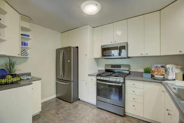 a kitchen with refrigerator a microwave a stove and cabinets