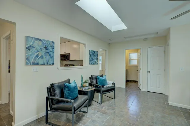 a living room with furniture and a painting on the wall