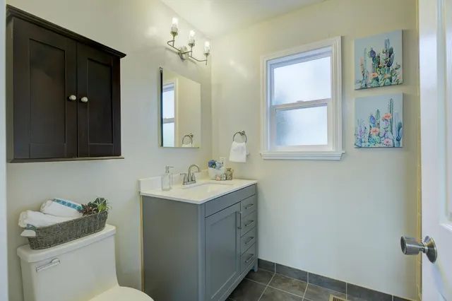 a bathroom with a toilet sink and mirror