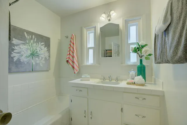 a bathroom with a bathtub sink and mirror