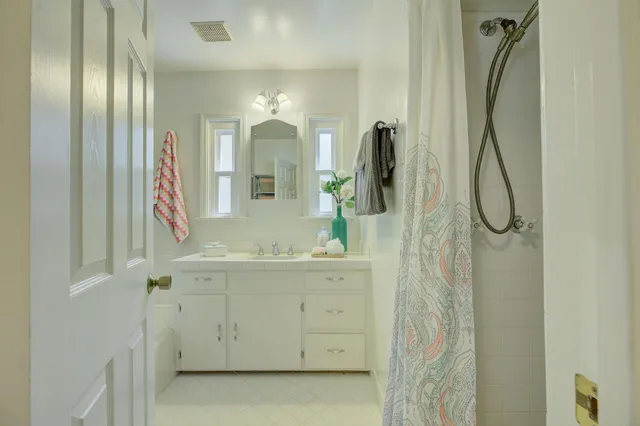 a bathroom with a mirror sink and glass door