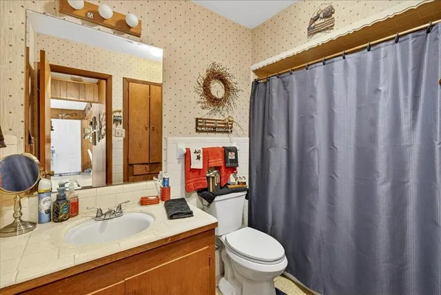 a bathroom with a sink vanity mirror and toilet