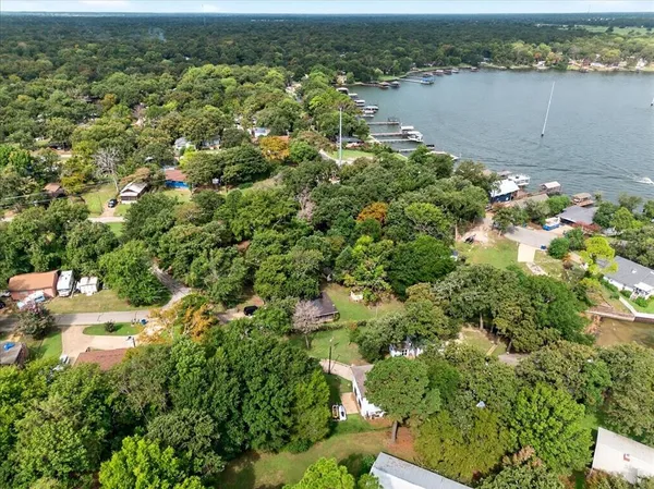 an aerial view of residential houses with outdoor space and trees