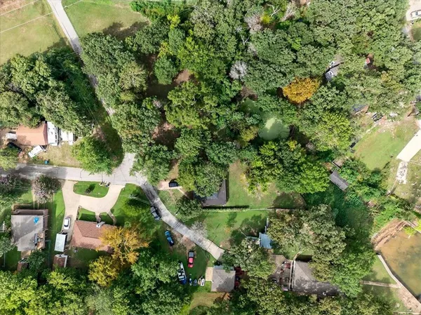 an aerial view of residential house with outdoor space and trees all around