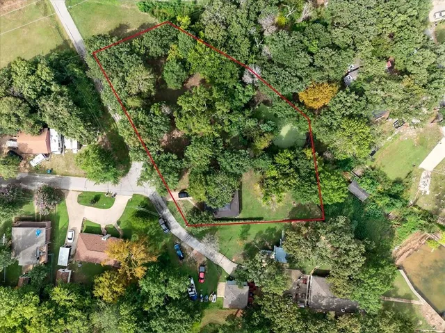 an aerial view of residential house with outdoor space and trees all around