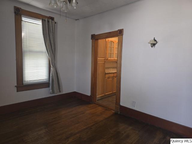 210 Main Street Carthage, IL 62321 - Photo 5 of 36 an empty room with wooden floor and windows