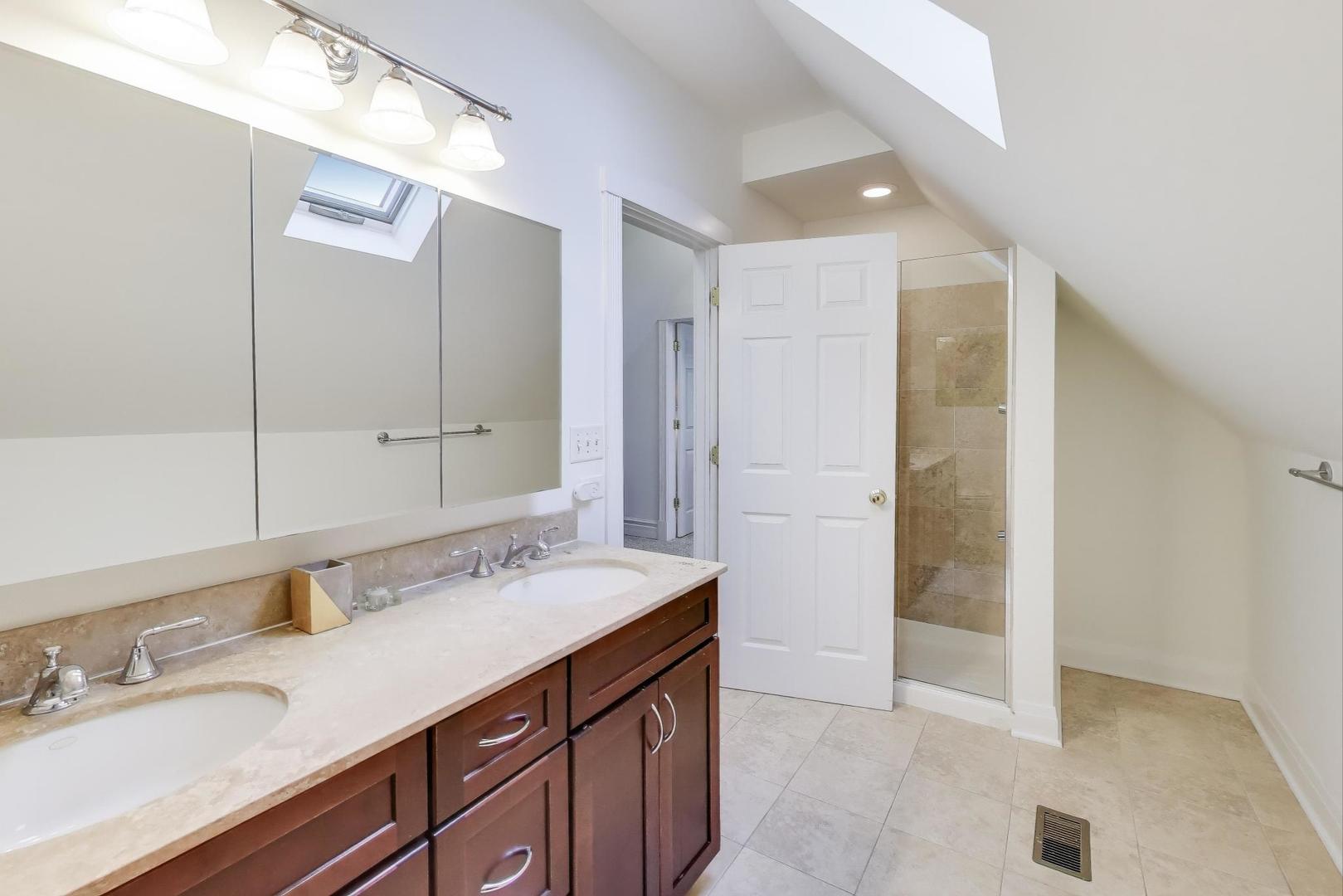3615 North Hoyne Avenue, Unit 2F Chicago, IL 60618 - Photo 19 of 24 a spacious bathroom with a sink and a mirror