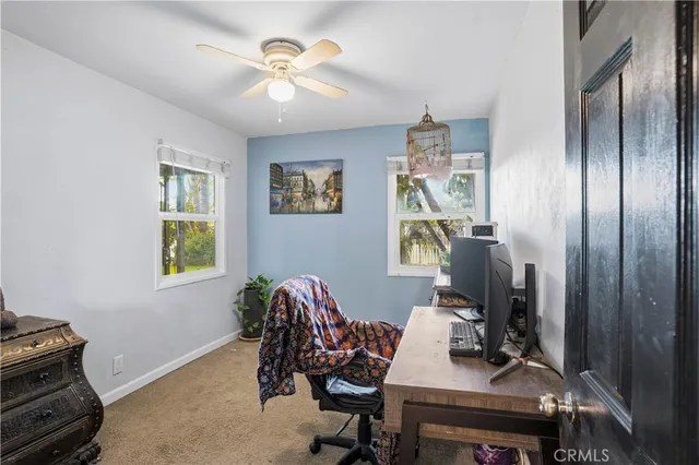 a bedroom with a bed a dresser next to a window