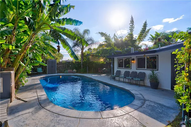a view of a house with swimming pool and sitting area