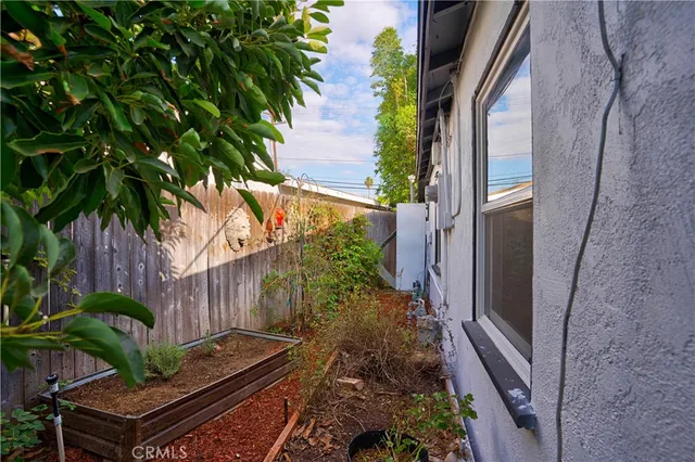 a view of a patio with table and chairs under an umbrella with wooden fence
