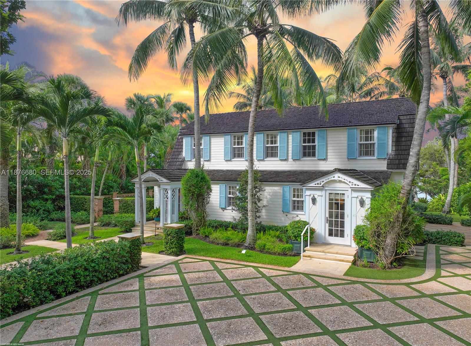 a front view of a house with a yard and potted plants