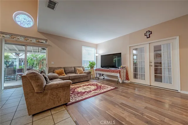 a living room with furniture a flat screen tv and a large window
