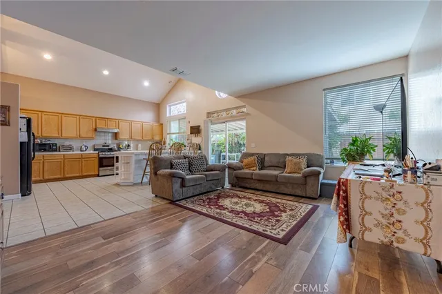 a living room with furniture rug and kitchen view