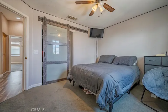 a spacious bedroom with a bed and a chandelier