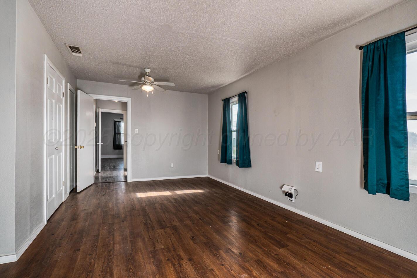 8015 Upton Road Amarillo, TX 79119 - Photo 9 of 16 a view of an empty room with wooden floor and a window