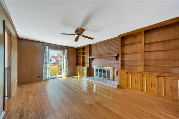 a view of a livingroom with wooden floor and a ceiling fan