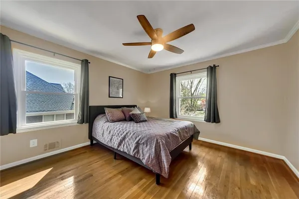 a bedroom with a bed wooden floor and a window