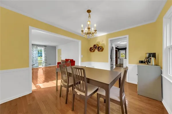 a large white kitchen with granite countertop a sink window and cabinets