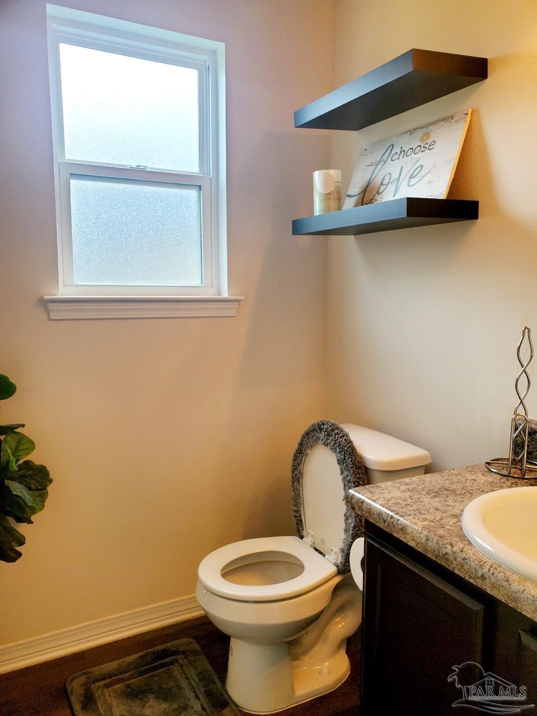 5845 Fairlands Road Milton, FL 32583 - Photo 6 of 21 a bathroom with a granite countertop toilet and a sink