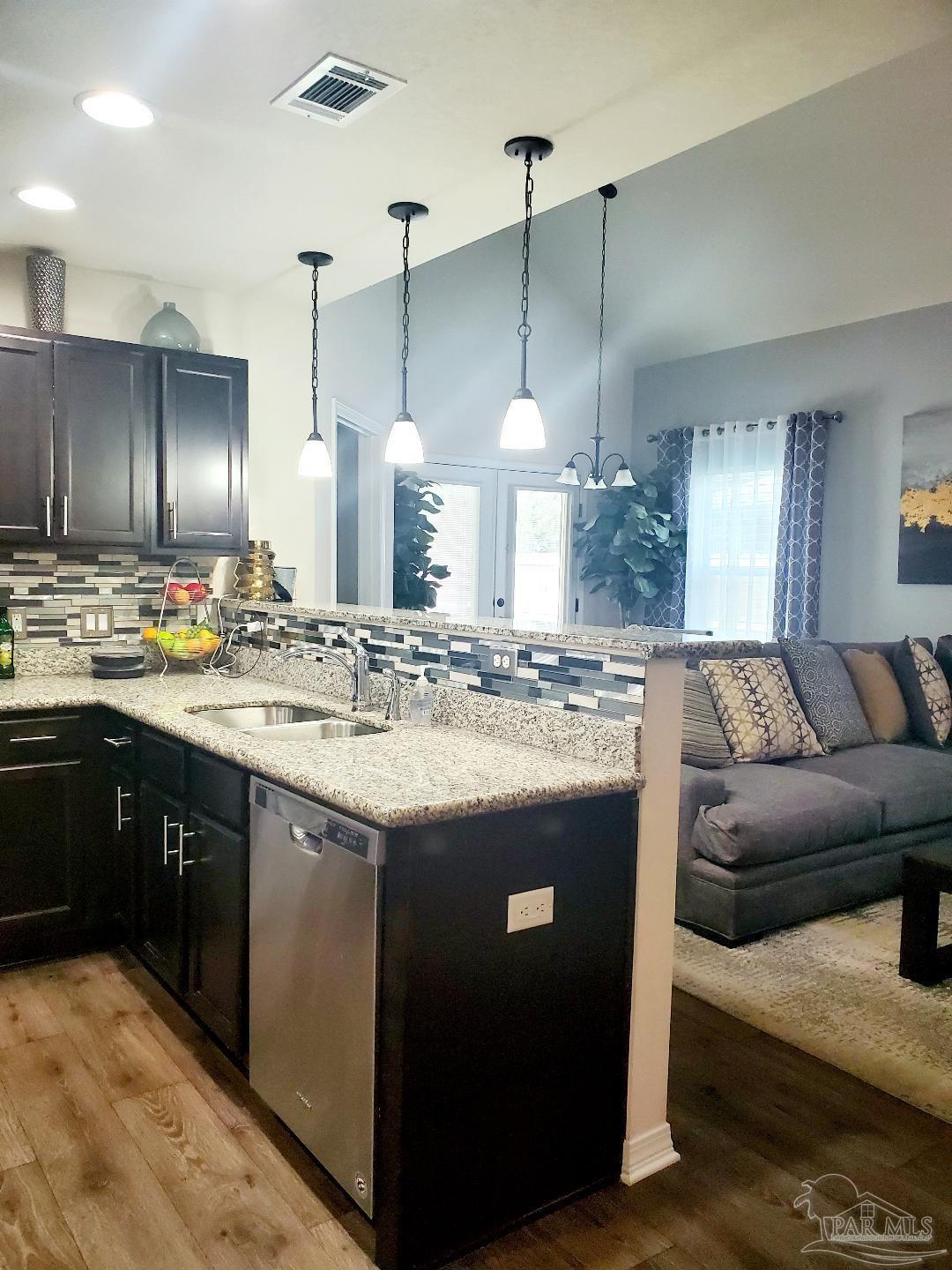 5845 Fairlands Road Milton, FL 32583 - Photo 7 of 21 a kitchen with kitchen island granite countertop a sink and a wooden floor