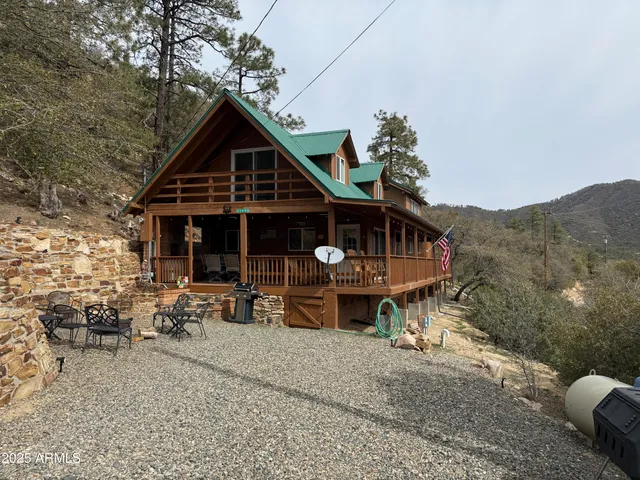 a view of a house with wooden deck and furniture